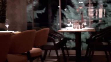 Ormana bakan masaları olan boş bir restoranda şömine var. İç mekan. Yanan odun şöminesi. Dağa bakan romantik mum ışığında romantik bir akşam yemeği. İyi akşamlar..
