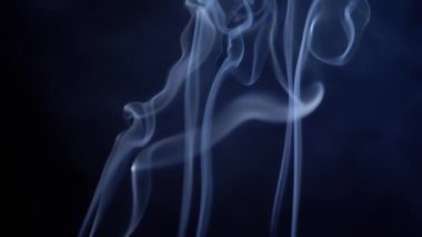 Mavi Bukleli İnce Duman Yükseliyor, Boşluğu Siyah Arkaplanda Doldur. Tütsü çubukları. Soyut şekiller. Doku. Güzel duman bulutları fırıl fırıl dönüyor. Yüzen sis, akan duman. Bulanık hareket. Işık.