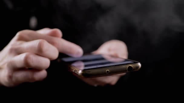 女性手指在手机社交网络中滚动新闻饲料 一个吸烟的女孩在一个昏暗的房间里 在智能手机上浏览手机应用程序 生活方式 — 图库视频影像