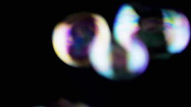 Bir sürü renkli sabun köpüğü Boşlukta Kara Arkaplanda uçuşuyor. Üfleme. Köpük. Sıvı şekiller. Kürelerin hızlı ve bulanık hareketi. Soyut, renkler. Seçici odaklanma. Siyahta izole edilmiş. Işık.