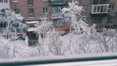 Pencere manzaralı, Kış Şehri manzaralı Eski Konut binalarının avlusunda. Üst Manzara. Panorama. Kar çok katlı binaların çatılarında yatar, ağaçlar karla kaplıdır. Bulutlu hava.