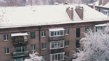 Eski Konut binalarının karla kaplı çatılarının avlu manzarası. Üst manzara, pencere. Karda balkonları olan çok katlı tuğlalar. Panorama. Hava bulutlu. Kış manzarası. Eski şehir.