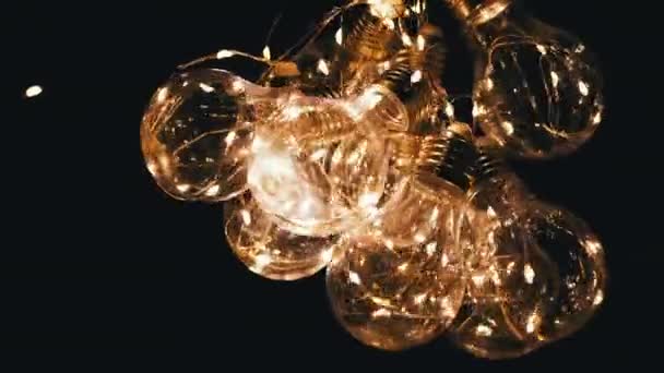 Kilka Świecących Girland Szklanych Żarówek Przyciemnionym Żółtym Światłem Ciemnym Pokoju — Wideo stockowe