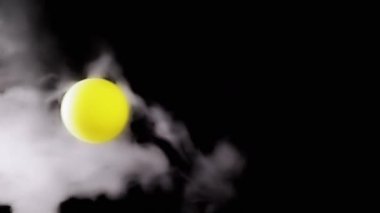 Dönen Sarı Küre 'nin çarpışması ve Boşlukta Bir Hava Akımında Duman. Siyah arka plan. Soyut. İzole edilmiş. Doku. Buzdan bir buhar bulutunun içinde dengede duran, uçan top. Işık. Yana. Yükselme.