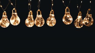 Birçok Sallanan Parıldayan Vintage Edison ampulleri Kara Arkaplanda. Arka arkaya. Noel süslemeleri, klasik elektrik ampulleri açılıp kapanıyor, retro tarzı çelenkler mekanı aydınlatıyor.