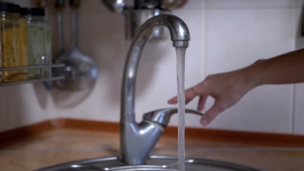 在模糊的背景下 用手打开厨房自来水水龙头 靠近点干净 透明的水流入水池 慢动作家庭消费 节约自然水资源 — 图库视频影像