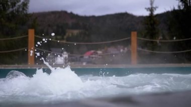 Dışarıdaki termal kaplıcalardan gelen sıcak suyla kaynayan jakuziyi boşalt. Bir damla su, köpüklü çeşme. Jakuzi, Carpathian dağları manzaralı yüzme havuzu. Spa tedavisi. Sağlık Oteli.