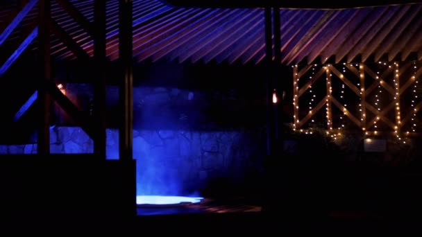 ホテルスパテラスで夜にネオンライト付きの空の高級屋外ホットタブ 温泉から温水でプールまたはジャグジー フリッカーブルーライト 水蒸発する ウェルネス — ストック動画