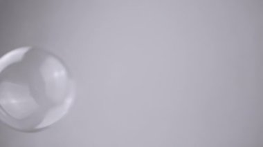 Grup Sabun Baloncukları Boş Alan 'da Gri Bir Arkaplanda İlerliyor. Kapatın. Büyük, küçük şeffaf su küreleri üflüyorlar. Soyut. Bulanık hareket, odaklan. İzole edilmiş. Krom anahtar. Tek renkli olsun. Yavaş çekim.