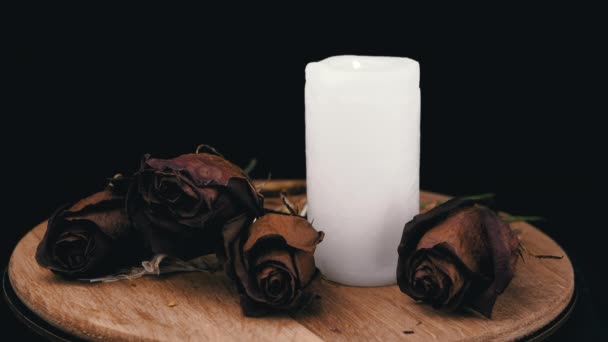 Καίγοντας Λευκό Κερί Και Τέσσερα Μαραμένα Ξηρά Τριαντάφυλλα Μαύρο Φόντο — Αρχείο Βίντεο