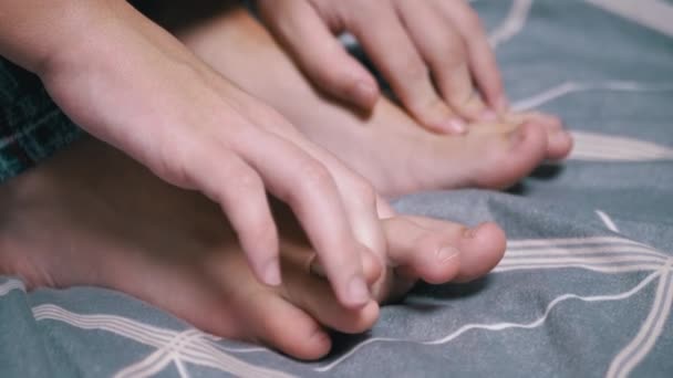 近距离接触时 小孩用手在卧室的床上按摩他疲惫的脚 擦拭皮肤 消除疼痛症状 放松点 四肢的运动 — 图库视频影像