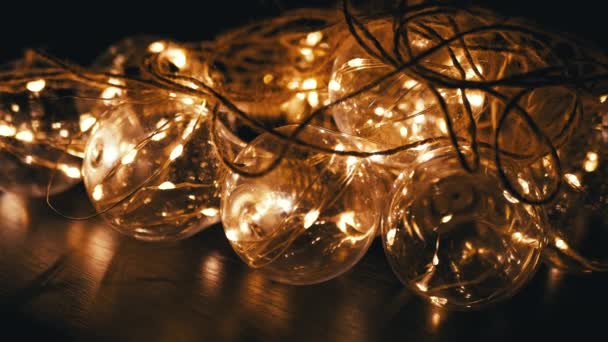 Gloeiende Slinger Van Glazen Lampjes Met Dim Geel Licht Een — Stockvideo
