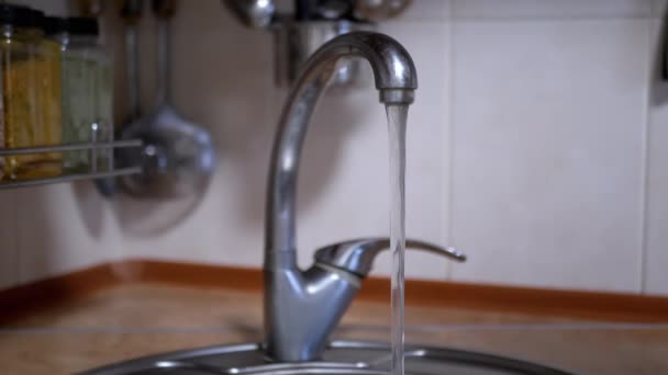 Van Dichtbij Stroomt Water Uit Een Waterkraan Een Wazige Keukenachtergrond — Stockvideo