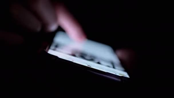 女性手指在手机社交网络中滚动新闻饲料 模糊的 靠近点手指在黑暗的房间里触摸屏幕 女人在晚上用智能手机上网浏览视频 小玩意的夜生活 — 图库视频影像