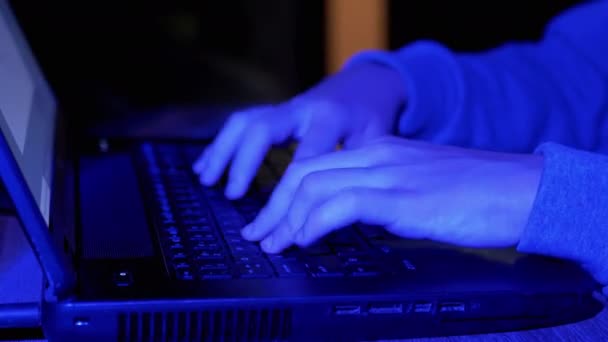 クローズアップ ネオン照明付きダークルームのキーボード上の男性タイピングの手 ボーイゲーマーはビデオゲームをしています ボディパーツ エスポート競技やフリーランサー 夜間にリモートで作業するハッカー ライフスタイル — ストック動画