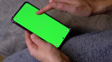 Yatma Vakti 'nde Yeşil Ekranlı Kadın El Tutma Akıllı Telefonu. Kopyalama alanı için krom anahtar düzeni. Parmaklar haber yayınında kayıyor, akıllı telefonun parmakları ile renkli ekranında video.