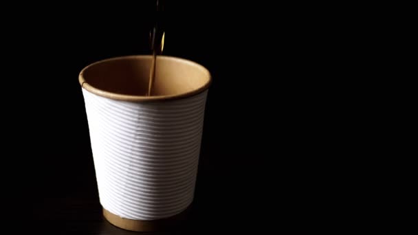 在黑色背景的白纸杯中倒入热茶或咖啡 模糊的运动 复制空间 咖啡外卖 孤立无援集中精神咖啡饮料 — 图库视频影像