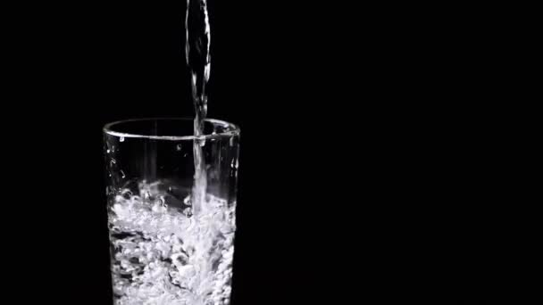 Tiszta Ivóvíz Öntése Egy Vizes Pohár Vízbe Fekete Alapon Elszigetelve — Stock videók