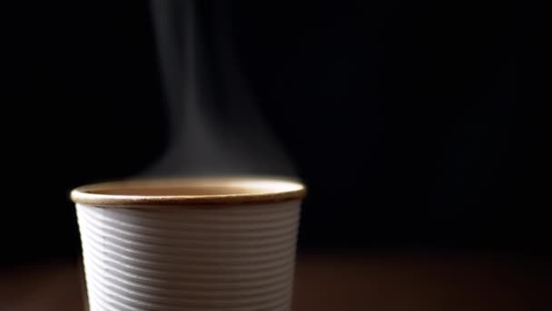 热蒸汽从纸杯热咖啡的黑色背景上升 模糊的运动 复制空间 咖啡外卖 孤立无援集中精神咖啡饮料的概念 — 图库视频影像