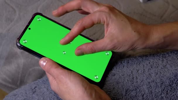 Женщина Держит Смартфон Зеленым Экраном Комнате Пальцы Открывают Экран Мобильного — стоковое видео