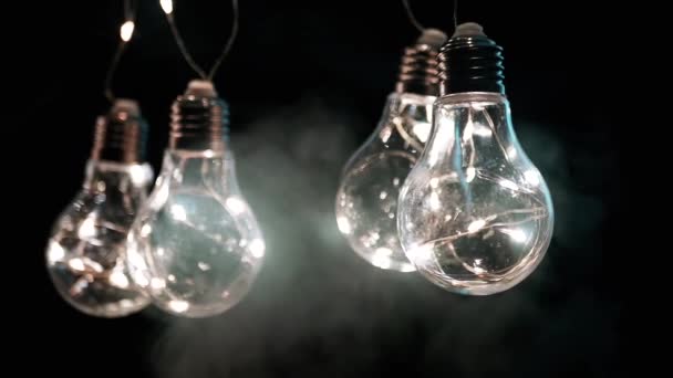 Hängande Glödande Vintage Edison Glödlampor Rök Svart Bakgrund Varmt Ljus — Stockvideo