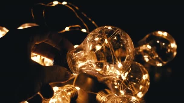 Hand Hält Eine Flackernde Glühbirne Auf Dem Hintergrund Glühender Glühbirnen — Stockvideo