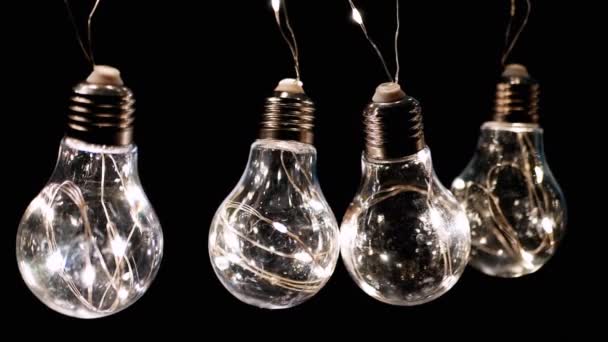 Fyra Hängande Glödande Vintage Edison Glödlampor Svart Bakgrund Varmt Ljus — Stockvideo