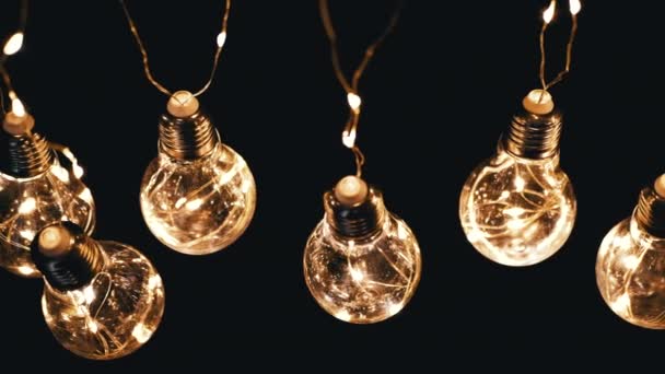 Veel Opknoping Gloeiende Vintage Edison Lampen Zwarte Achtergrond Bovenaanzicht Warm — Stockvideo