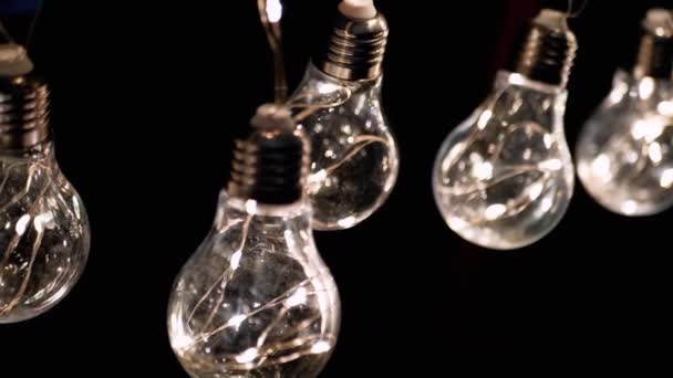 Ragyogó Vintage Edison Izzók Függenek Mennyezeten Egy Fekete Háttér Egymás — Stock videók