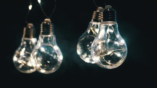 Glühende Edison Glühbirnen Hängen Rauch Auf Schwarzem Hintergrund Warmes Licht — Stockvideo