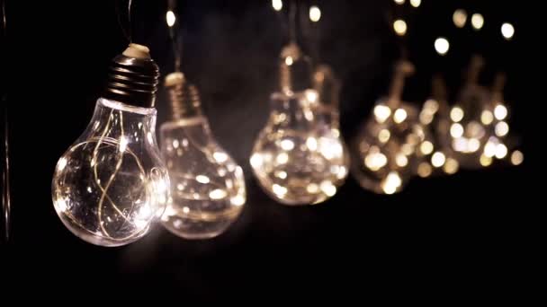 Pendurado Brilhante Vintage Edison Lâmpadas Fumaça Fundo Preto Luz Quente — Vídeo de Stock