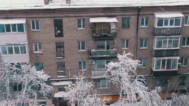 旧楼庭院中的冬季城市景观 窗户景观 顶部视图 雪落在多层楼房的屋顶上 树木被雪覆盖 多云的天气 — 图库视频影像