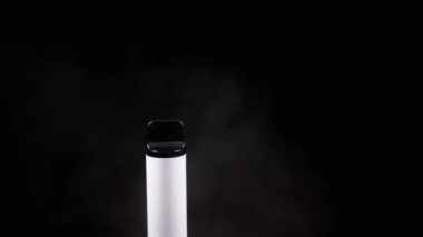 White Electronic Cigarette veya Vape in Smoke on a Black Background in Empty Space. E-sigara. Bulanık hareket. Buhar dokusu. Koyu gri duman bulutları. Kötü alışkanlıklar. Alternatif. Sigara içiyorum. Yavaş çekim.