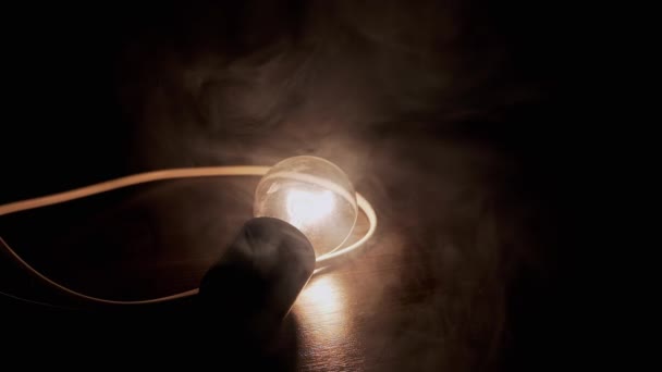 Glödande Glödande Glödlampa Med Tråd Lies Ett Träbord Rök Konsistens — Stockvideo
