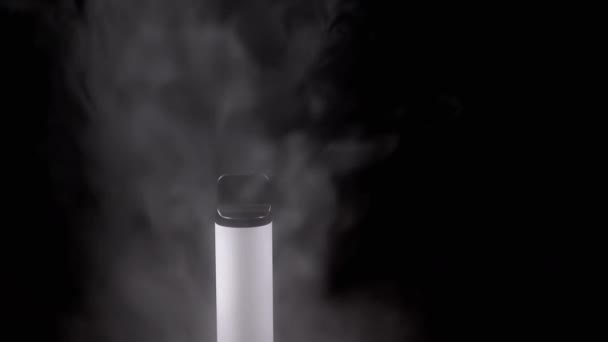 白い電子タバコまたは煙のヴァイプ 空のスペースの黒い背景で 電子タバコ ブレイクした動き スチームテクスチャ 灰色の煙の厚いパフ 悪い習慣がある オルタナティブ 喫煙する スローモーション — ストック動画