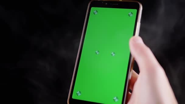 Hand Holding Mobile Phone Green Screen Black Background Smoke Smartphone — Stock Video