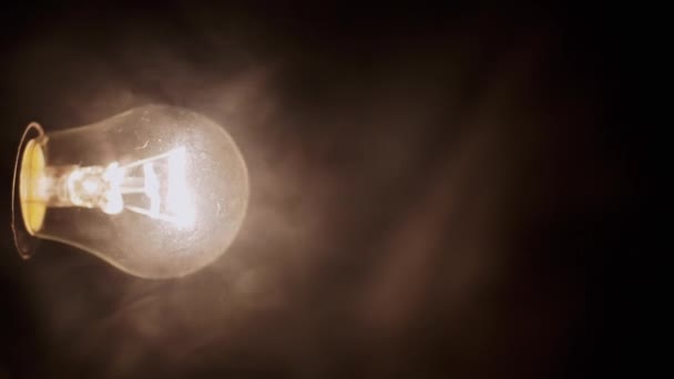 Одна Сяюча Лампа Розжарювання Густому Димі Чорному Тлі Вид Збоку — стокове відео
