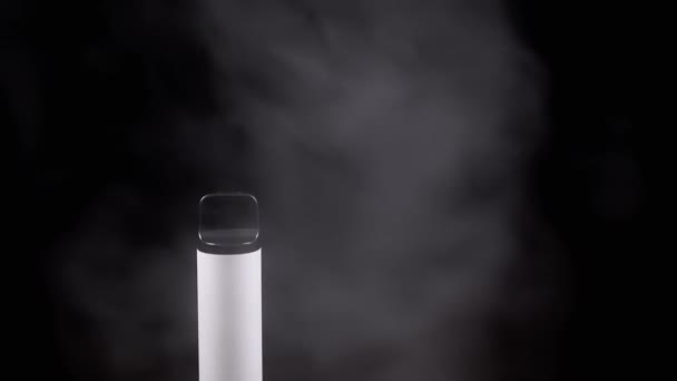 白い電子タバコまたは煙のヴァイプ 空のスペースの黒い背景で 電子タバコ ブレイクした動き スチームテクスチャ 灰色の煙の厚いパフ 悪い習慣がある オルタナティブ 喫煙する スローモーション — ストック動画