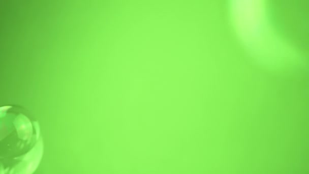 クローズアップ ロトソープ泡は 空のスペースの緑の背景に浮きます 分子について カオスムーブメント 透明な虹彩水球を吹き飛ばしています アブストラクト ブレイクされた動き 孤立した クロマキー — ストック動画