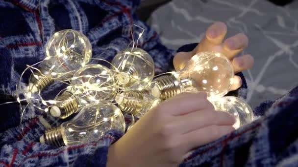 Дитина Тримає Багато Світяться Різдвяні Лампи Руках Лежачи Ліжку Кімнаті — стокове відео