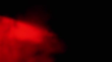 Kızıl Duman 'ın patlaması ya da Siyah Bulanık Arkaplanda Toz. Soyut, yan görüş. Kırmızı yumuşak duman veya buhar kaotik bir şekilde boş uzayda karışıyor. Parçacık patlaması, parlak ışık. Yavaş çekim.