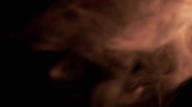 Portakal Dumanı Patlaması ya da Siyah Bulanık Arkaplanda Buhar. Soyut. Yan görüş. Yumuşak dumanlar ya da boş uzayda kaotik bir şekilde buhar karışımı. Parçacık patlaması, parlak ışık. Yavaş çekim.