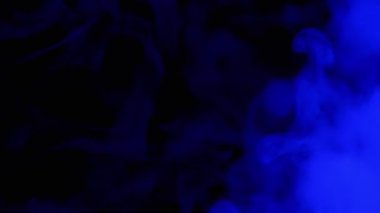 Mavi Duman 'ın patlaması ya da Siyah Bulanık Arkaplanda Buhar. Soyut. Yan görüş. Yumuşak dumanlar ya da boş uzayda kaotik bir şekilde buhar karışımı. Parçacık patlaması, parlak ışık. Yavaş çekim.