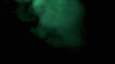 Siyah Bulanık Arkaplanda Yeşil Duman veya Buhar Patlaması. Soyut. Dolu. Flaş. Yumuşak dumanlar ya da boş uzayda kaotik bir şekilde buhar karışımı. Parçacık patlaması, parlak ışık. Yavaş çekim.