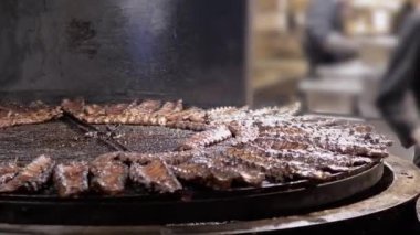 Büyük Dönen Kömür Izgarasında Kızarmış Domuz Pirzolası Pişirme Süreci. Kapatın. Şef, lokantada kızarmış pirzola ya da mangalda kızartma hazırlıyor. Domuz pirzolası dumanhanede ateşte pişiyor..