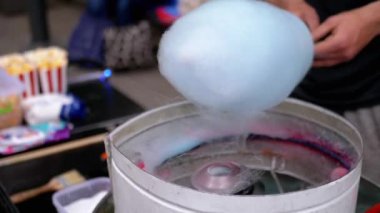 Satıcı, Pamuk Şeker Yapıyor, Sokaklarda Pamuk Şeker Yapan Bir Makine. Parkta pamuk helva için şekerden havadar bir mavi bulut yapma süreci. Çocuklar için bir parti. Sokak şekeri satıyorum..