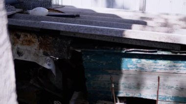 Eski, yıpranmış bir köpek kulübesi yıkıntıların arasında, ihmal ve çürümeyi sembolize ediyor..