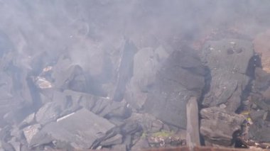 Paslı bir metal ızgarada yanan kömürün yakın plan çekimi, duman bulutu yaymak, sakin bir ortam yaratmak, yemek, yemek pişirme veya yaşam tarzı projeleri için mükemmel..