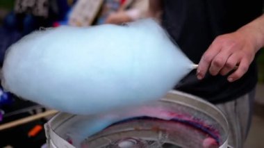 Satıcı, Pamuk Şeker Yapıyor, Sokaklarda Pamuk Şeker Yapan Bir Makine. Parkta pamuk helva için şekerden havadar bir mavi bulut yapma süreci. Çocuklar için bir parti. Sokak şekeri satıyorum..