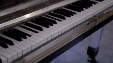 Piyano ya da Grand Piano Kendini Çalıyor. Kendi kendine çalan bir piyanoda müzik bestesi yapmak. Kendi kendine oynuyor. Beyaz, siyah piyano tuşları insan müdahalesi olmadan bağımsız olarak basılıyor. Kapat..